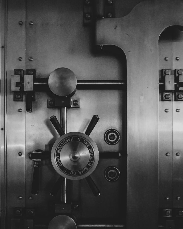 Closed steel vault door with its locking wheel and bolts