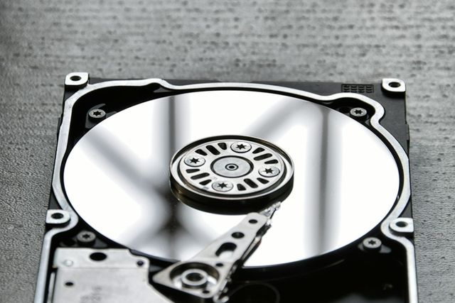 Open hard drive showing its platter and read arm