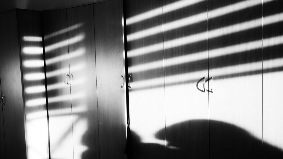 Striped shadows from window blinds across office cupboards