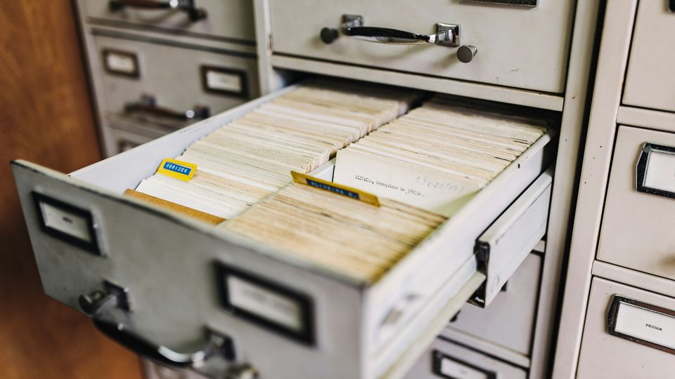 Filing cabinet with one drawer left open, full of index cards