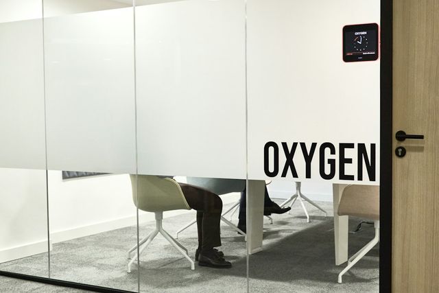 Meeting room behind frosted glass with someone seated at the table