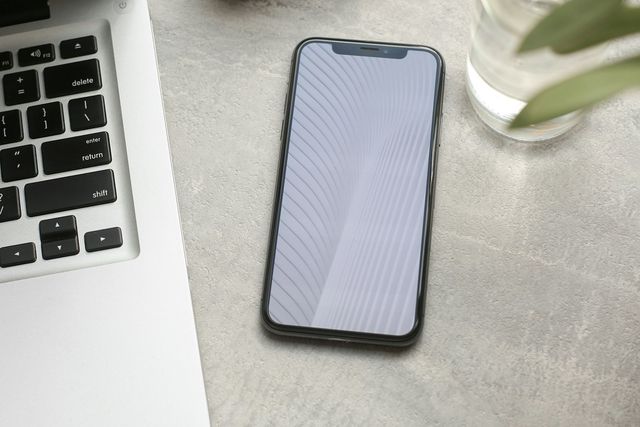 Smartphone on a desk beside a laptop